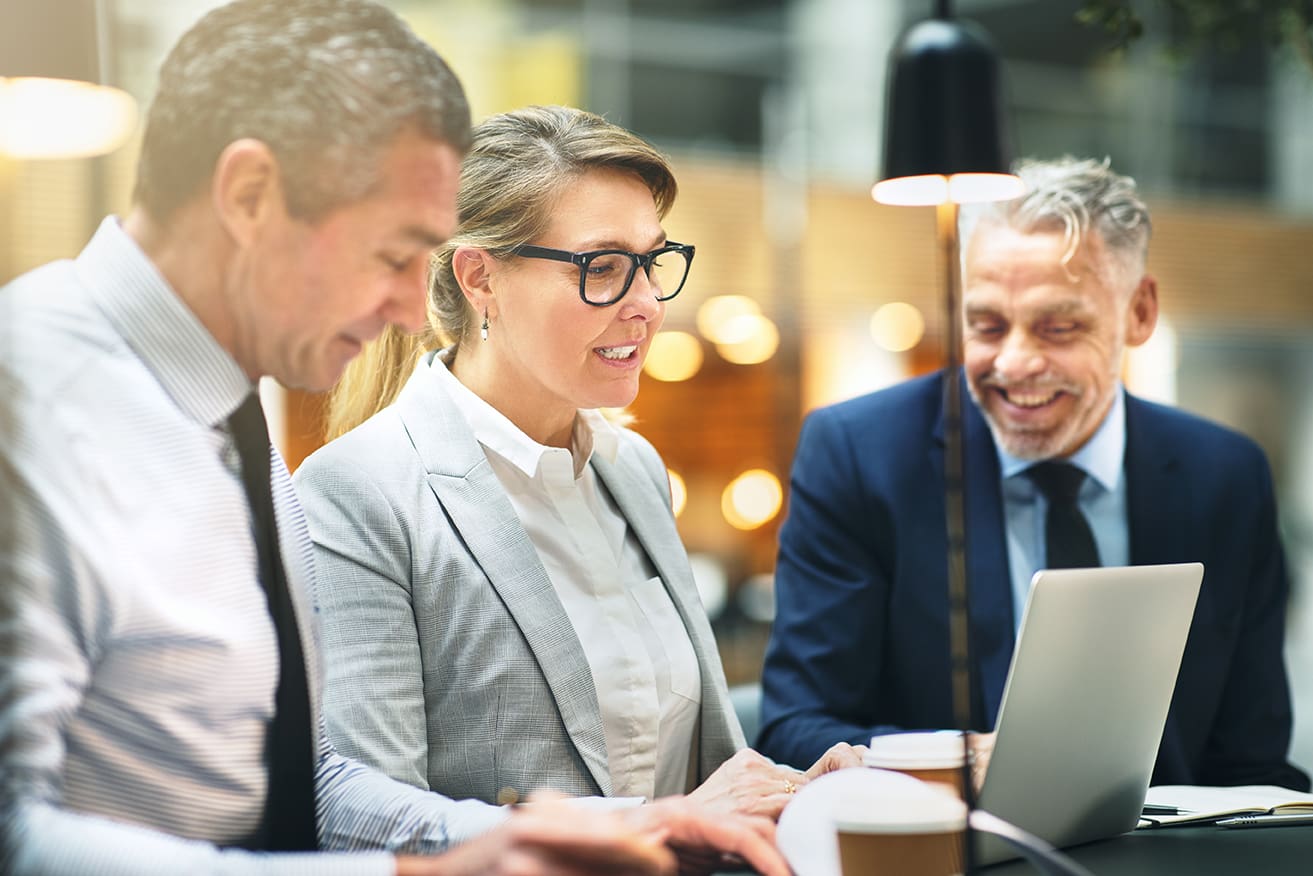 vrouw en mannen achter laptop